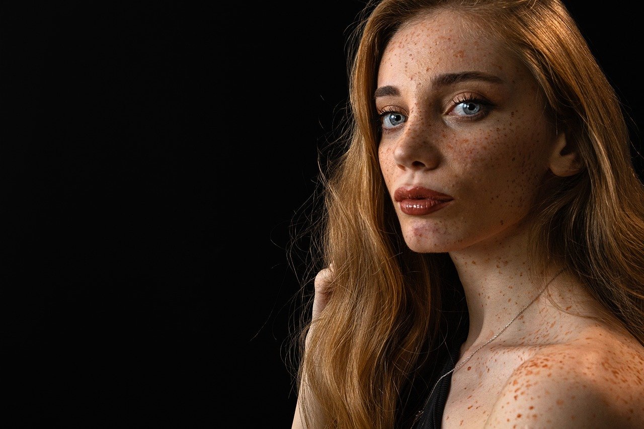 Donna che applica fondotinta coprente su pelle con vitiligine, evidenziando la bellezza e l'autenticità.